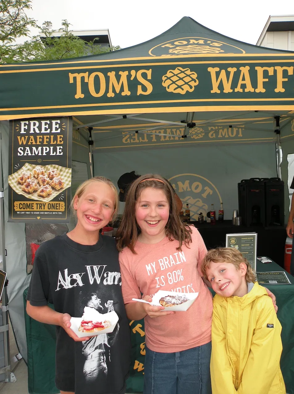 Kids enjoying fresh Belgian waffles at a Tom's Waffles birthday party event in Denver