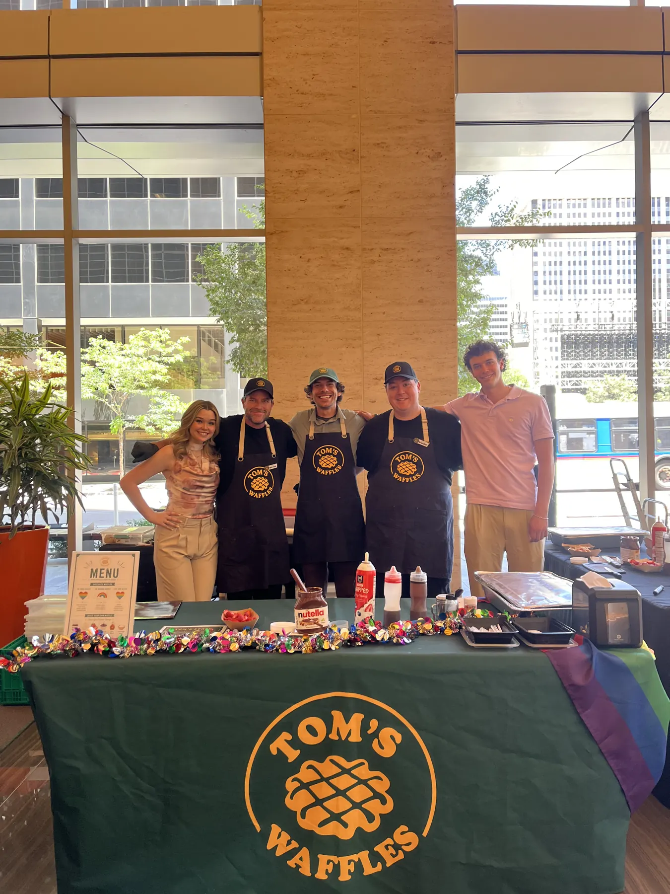 Five of our crew behind the Tom's Waffles table in an office lobby