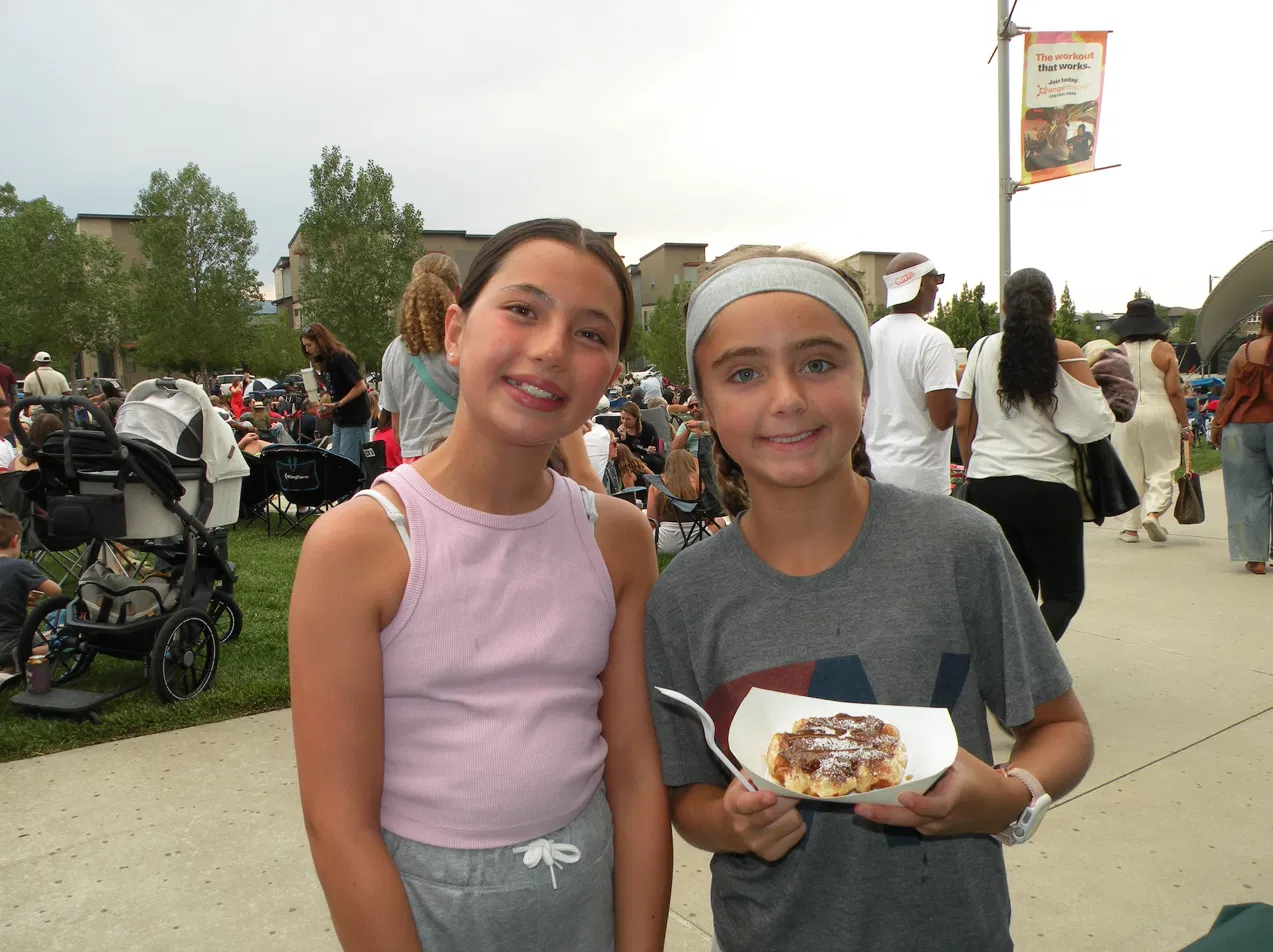 Kids and families enjoying fresh Belgian waffles at a Tom's Waffles apartment community event in Denver