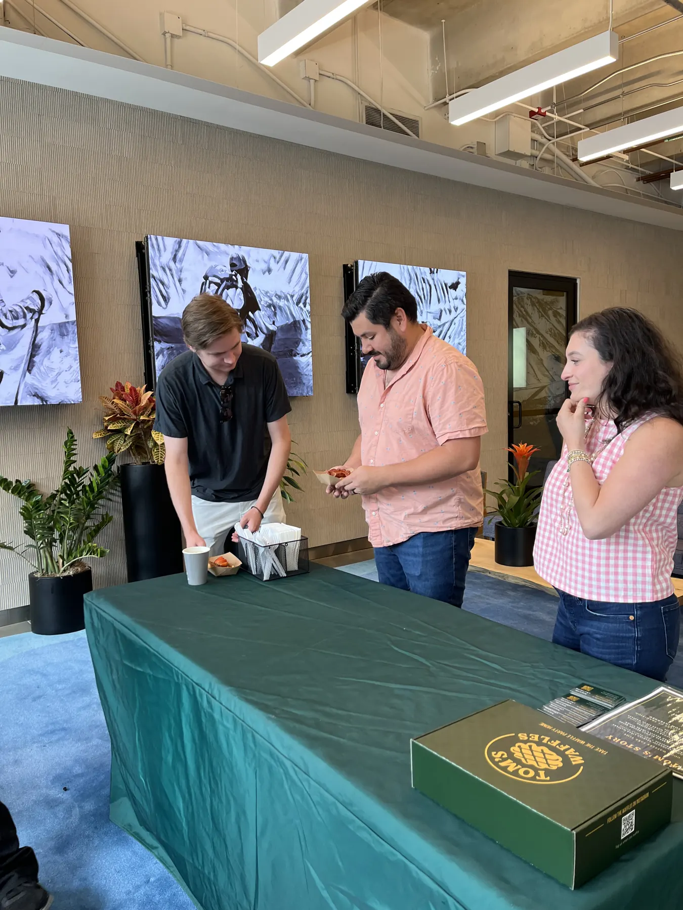 Coworkers picking up waffles at our table in an office lounge
