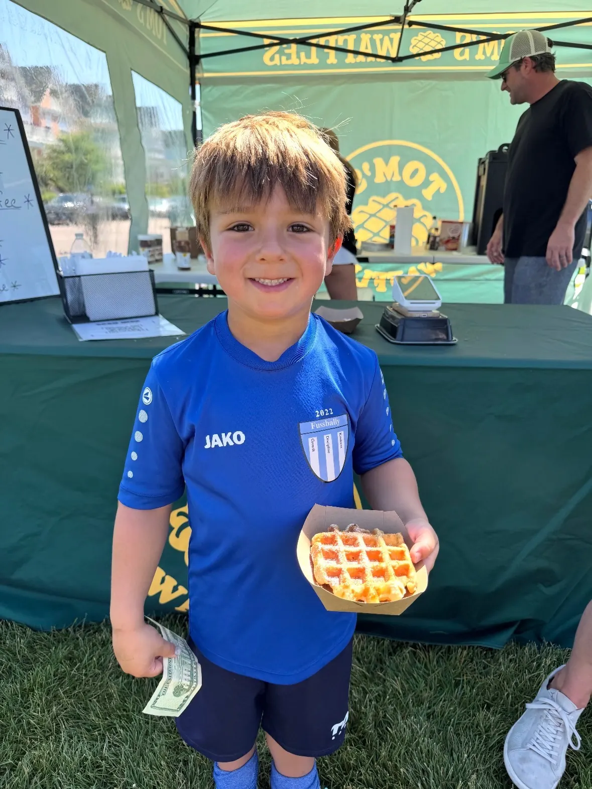 A young soccer player holding a waffle at a tournament